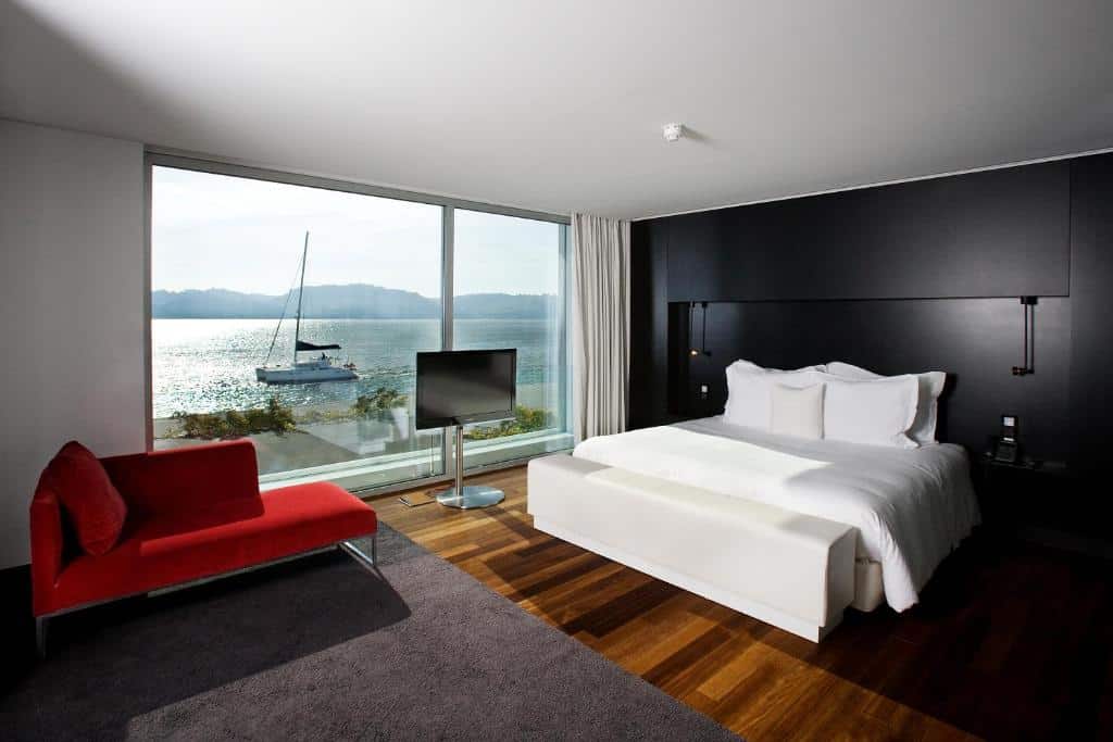 Quarto do Altis Belem Hotel & Spa com cama de casal e janela panorâmica com vista para o rio Tejo, em Lisboa