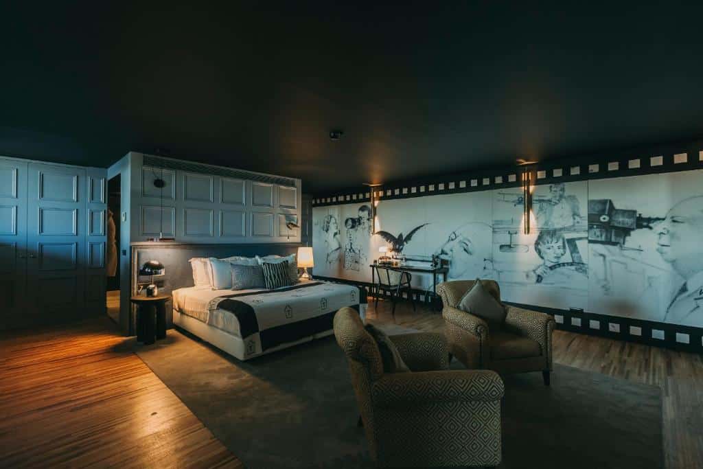 Quarto amplo e requintado do Torel Avantgarde, com cama ao centro, mesinhas de cabeceira com candeeiro e duas poltronas.