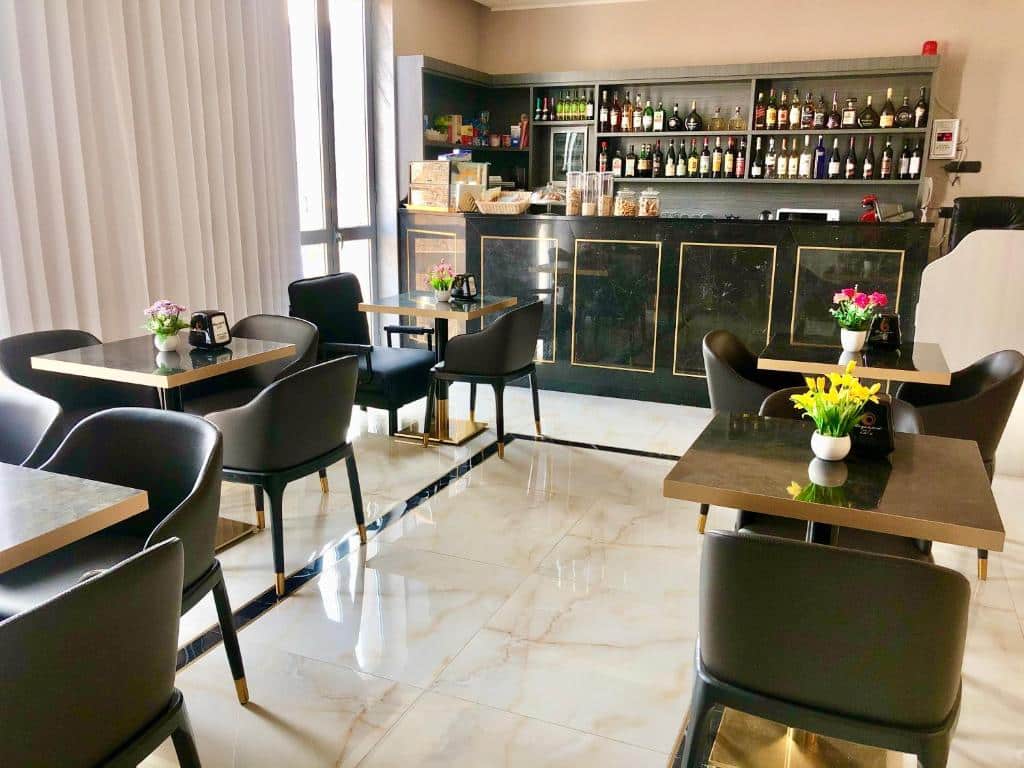Bar de estilo lounge com balcão, mesas e cadeiras no Hotel Folen