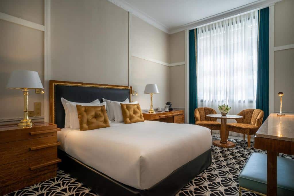 Quarto do Maison Albar Hotels Le Monumental Palace com cama de casal e mesinhas de cabeceira com candeeiro.