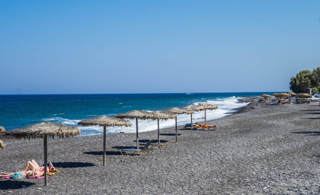 A praia de Kamari com chapéu de sol de palha