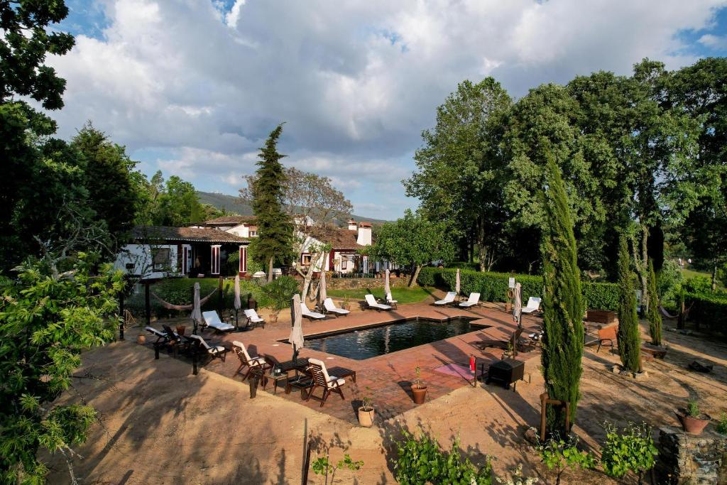 Piscina retangular em área exterior com casa tradicional ao fundo na Quinta da Dourada, em Portalegre