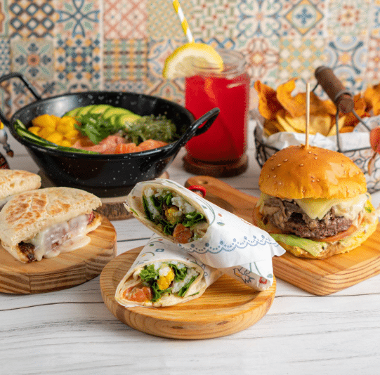 Alguns pratos do Bira dos Namorados, com tacos, hambúrgueres, sumos e batatas fritas.