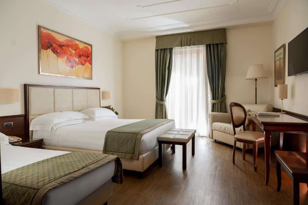 Quarto de hotel confortável com cama de casal e secretária, decoração clássica com pintura floral